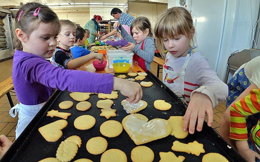 Mädchen und Jungen der Kita Bummi backen in der Landbäckerei Behrens Plätzchen. Die Einladung gab es zum 50. Bestehen.