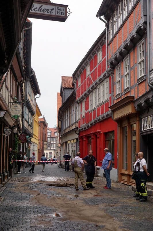 Siegfried Gaede vom ZVO und Holger Lindenberg, Geschäftsführer der Firma QHT (rechts), begutachten den Schaden in der Bockstraße in Quedlinburg.