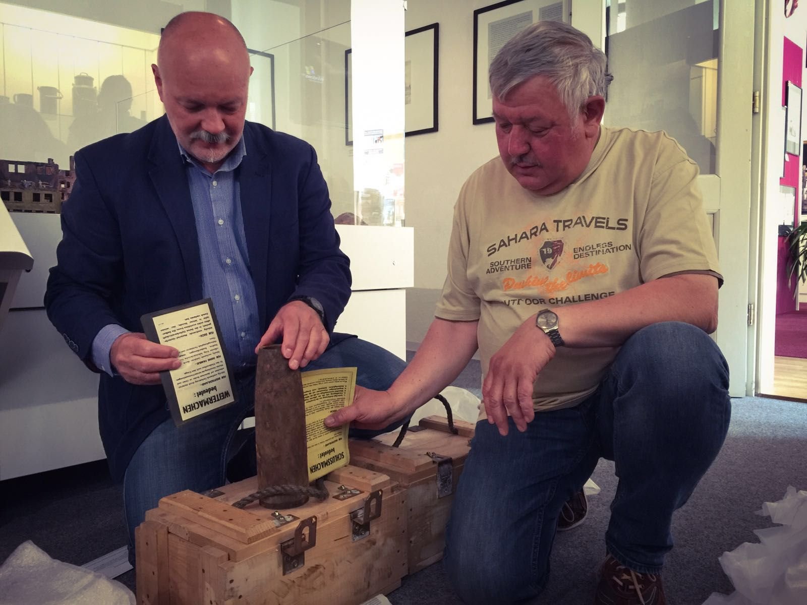 Museumsleiter Armin Schulze (l.) und Feuerwerker Ralf Habermann mit der Granate und Flugblättern, die zur Beendigung des Krieges aufrufen.