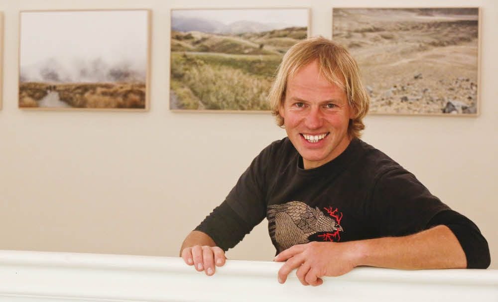 Falk Wenzel vor seiner Bilderserie in der neuen Stipendiaten-Ausstellung der Landeskunststiftung.