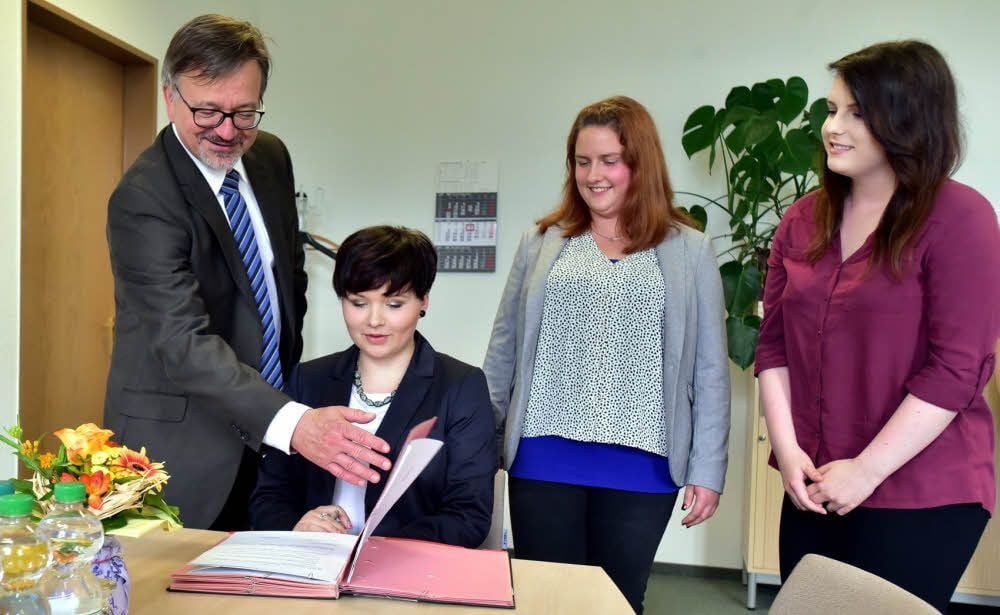Betriebsleiter Herwig Fischer hat die ersten Azubis des Jobcenters Burgenlandkreis begrüßt. Mareike Amme, Philine Grüner und Lisa-Marie Hofmann (von links) unterschreiben ihre Ausbildungsverträge.