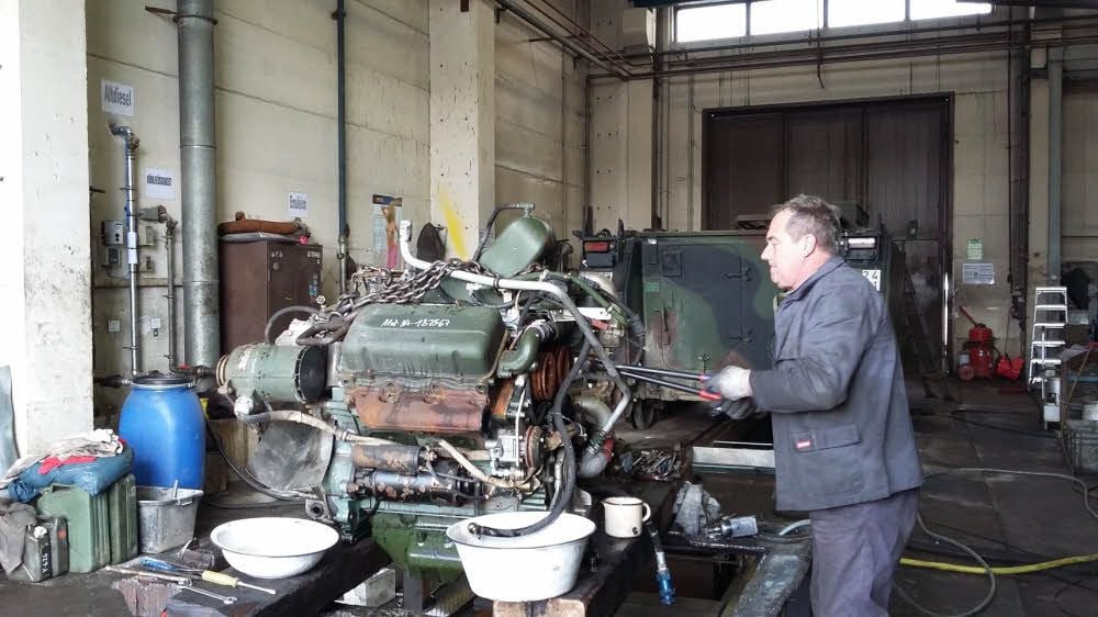 Monteur Ingolf Dyllus müht sich, einen Panzer-Motor zu zerlegen.