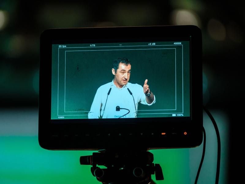 Auf einem Monitor ist der Bundesvorsitzende des Bündnis 90/Die Grünen, Cem Özdemir, zu sehen. Foto: Peter Steffen/Archiv