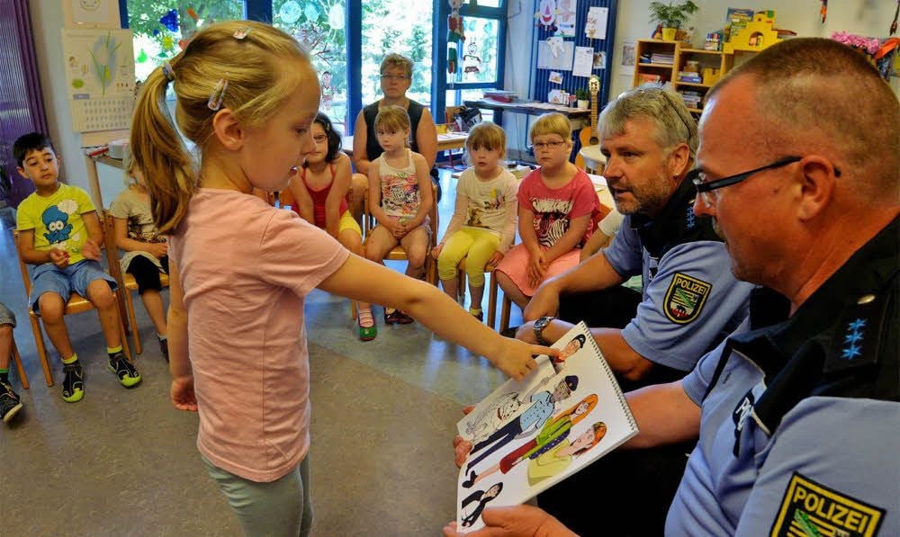 Klaus-Ulrich Schnita und Heiko Teschke (von rechts) zeigen Kindern in Gatersleben, wie sie sich vor Fremden schützen können.