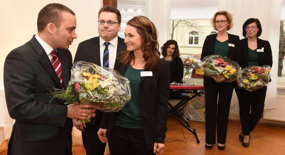 Geschäftsführer Lars Frohn gratuliert Jana Stockhaus zur Praxis-Eröffnung. Zum Team gehören (v.r.) Henriette König, Anke Sachse und Tobias Keller, kaufmännischer Leiter der Tochtergesellschaft. Im Hintergrund Pianistin Rahel Hutter.