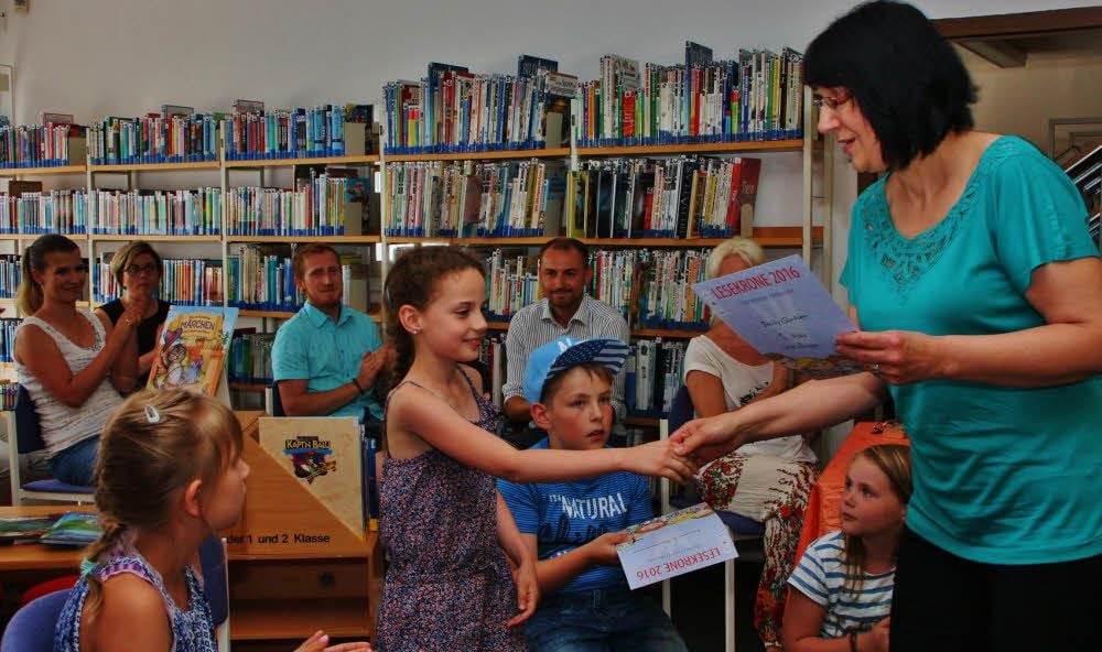 Susanne Besser, Mitarbeiterin der Hettstedter Stadtbibliothek, überreicht die Siegerurkunde an Emily Gürtler.