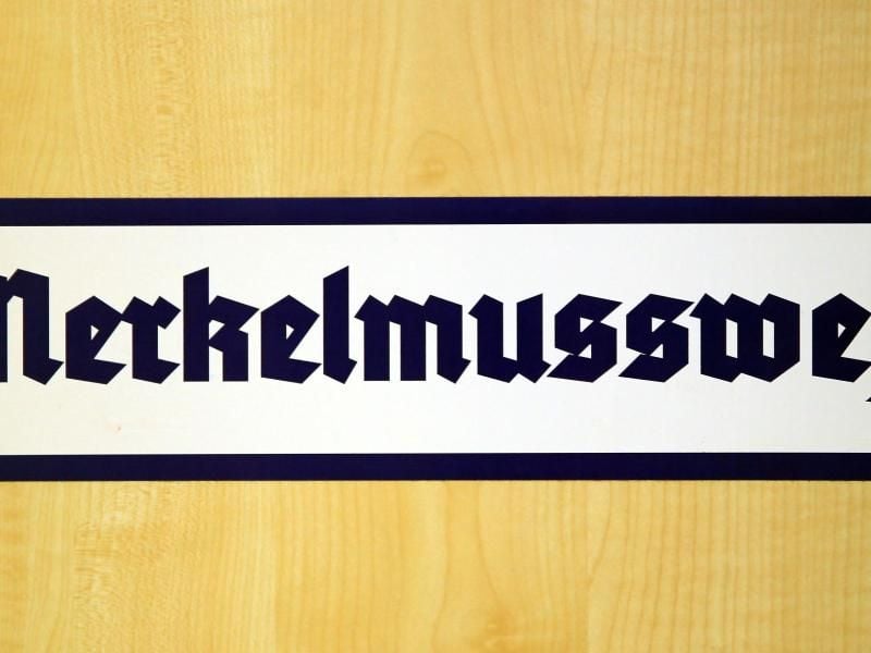 Ein Aufkleber mit der Aufschrift «Merkelmussweg» klebt Magdeburger Landtag. Foto: Peter Gercke