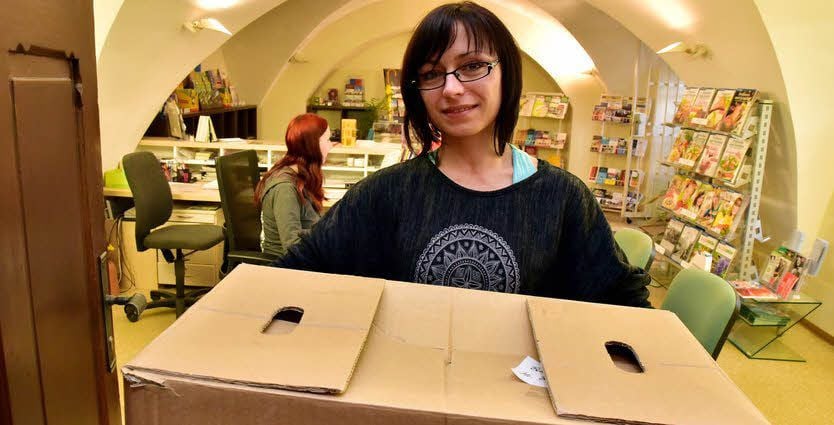 Brit Junghans packt einen Karton für den Umzug der Touristinfo.