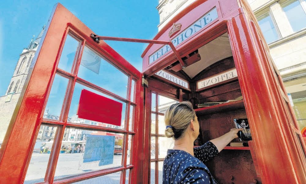 In der umgebauten Telefonzelle am Markt gibt es wenige Bücher, auch wenn Hallenser, so wie diese Frau, für Nachschub sorgen.