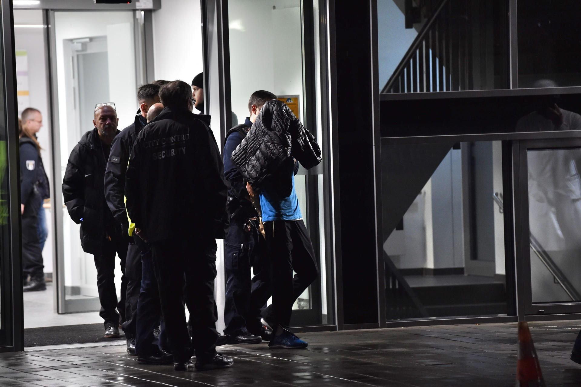 Polizisten führen den festgenommenen Tatverdächtigen ab.