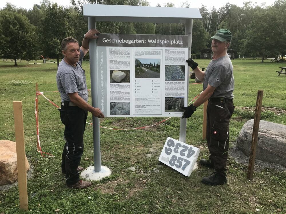 Die Gemeindearbeiter Frank Jacob (l.), der auch Bürgermeister ist, und Lutz Hennicke mit der neuen Tafel.