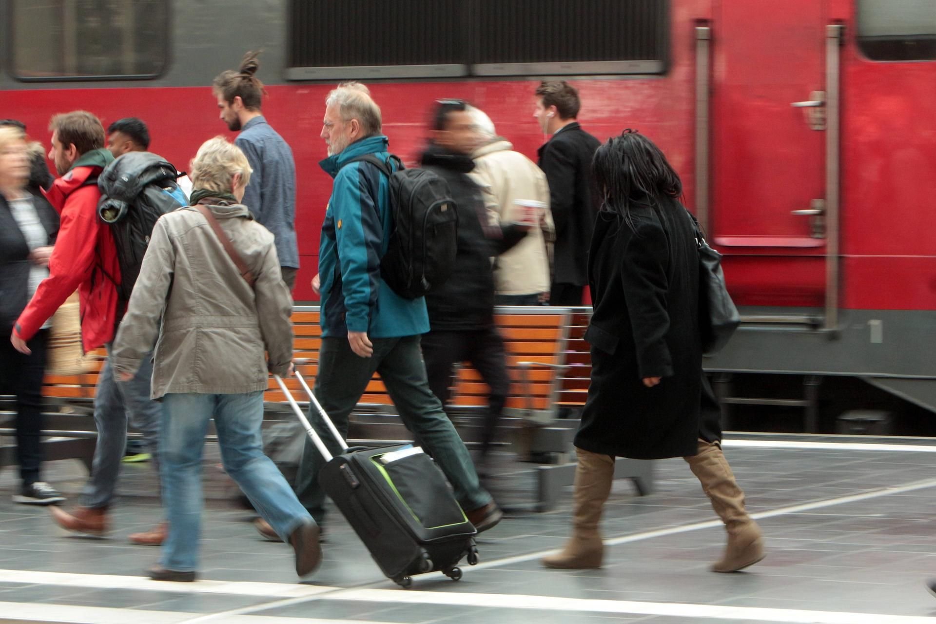 Symbolbild: Pendler eilen an einem Bahnsteig zum Zug.