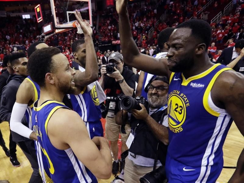 Stephen Curry (l) und Draymond Green (r) von Golden State feiern mit ihrem Team den Sieg über Houston. Foto: Eric Gay/ap