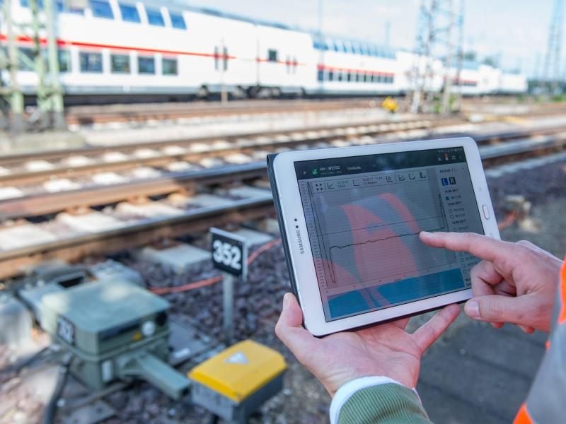 Samuel Schuster, Bezirksleiter in der Leit- und Sicherungstechnik bei der DB Netz AG, kontrolliert vor dem Hauptbahnhof in Hannover mit Hilfe seines Tablets eine Weiche. Foto: Silas Stein