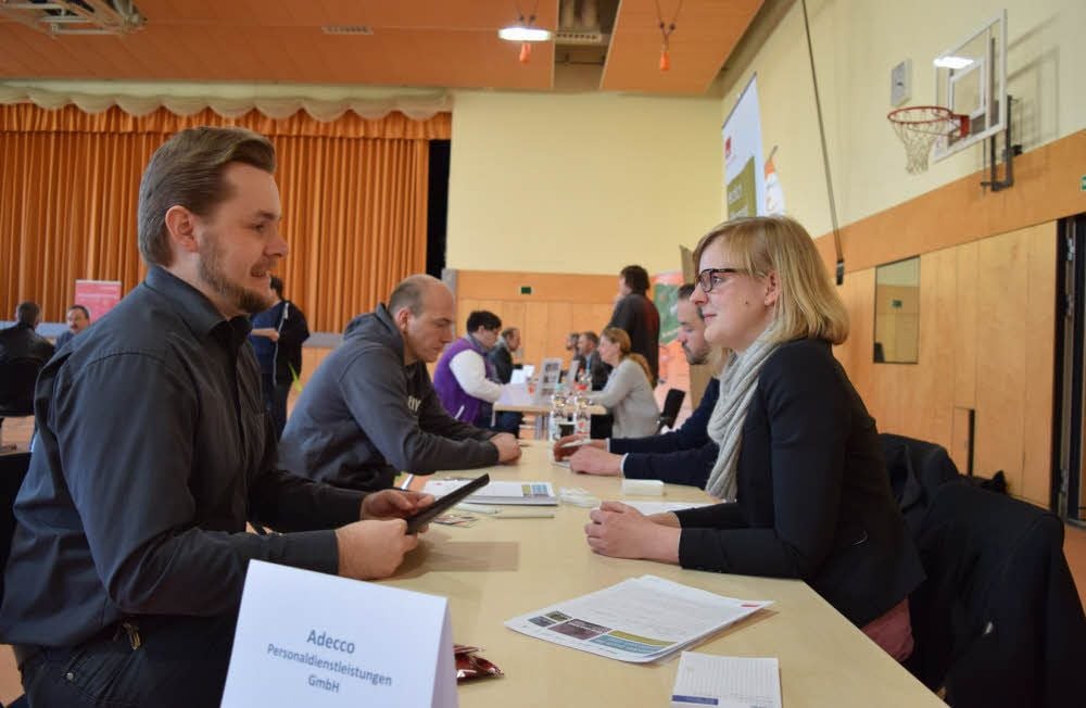 Marco Schwarz informiert sich beim Speeddating am Tisch des Personaldienstleisters Adecco bei Corinna Müller über Jobmöglichkeiten.