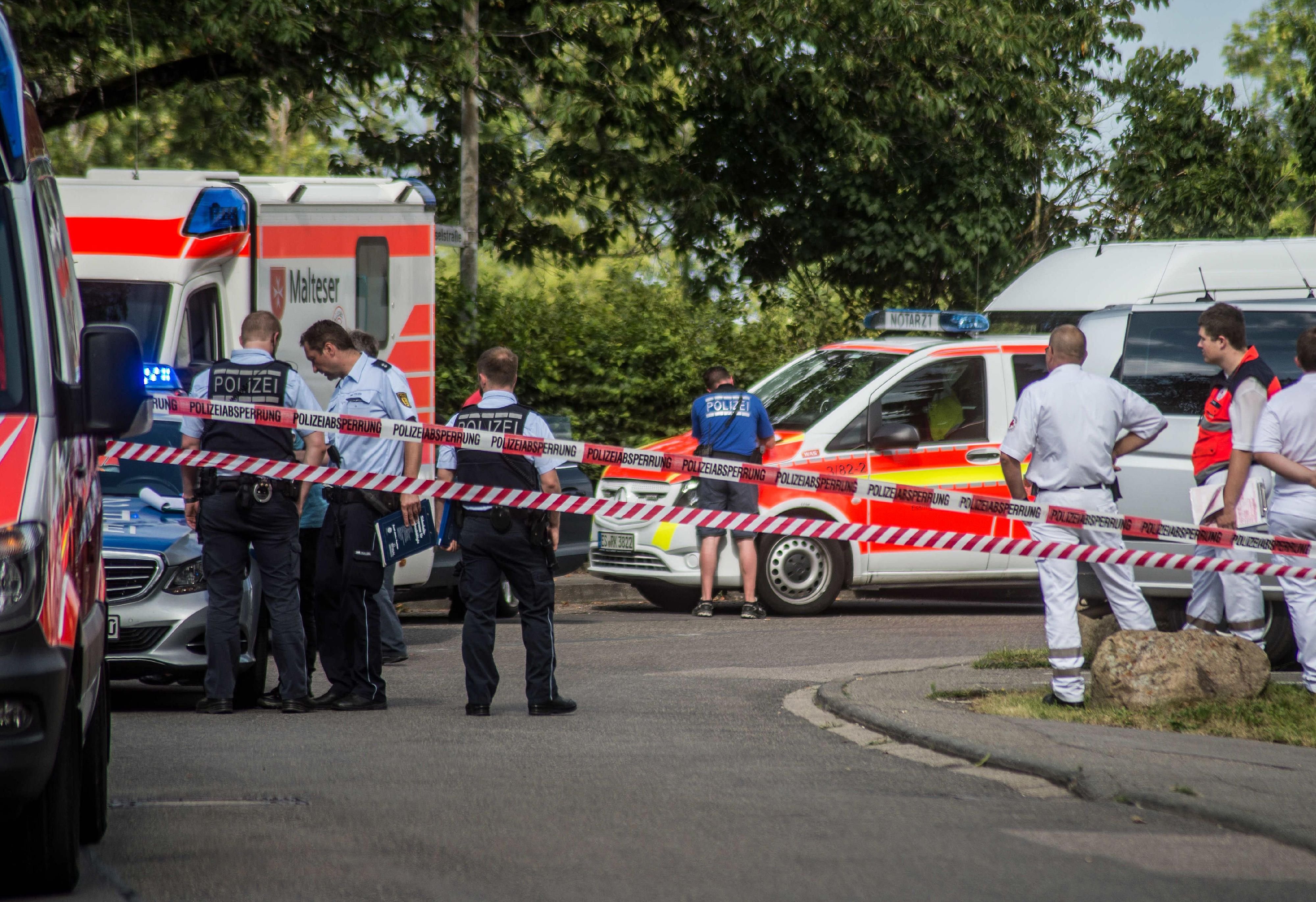 In Leinfelden-Echterdingen im Kreis Esslingen (Baden-Württemberg) stehen Einsatzkräfte von Polizei und Rettungsdiensten am Tatort vor einem Haus.