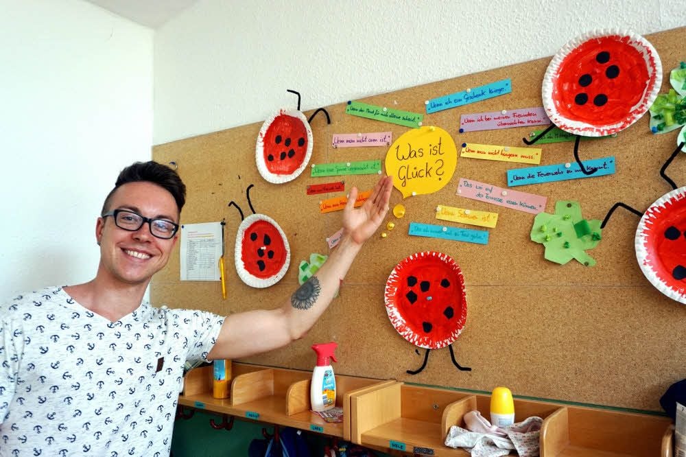 Daniel Siegmund zeigt stolz die Ideen der Kinder zum Thema. Passend dazu haben sie Glückssymbole gebastelt.