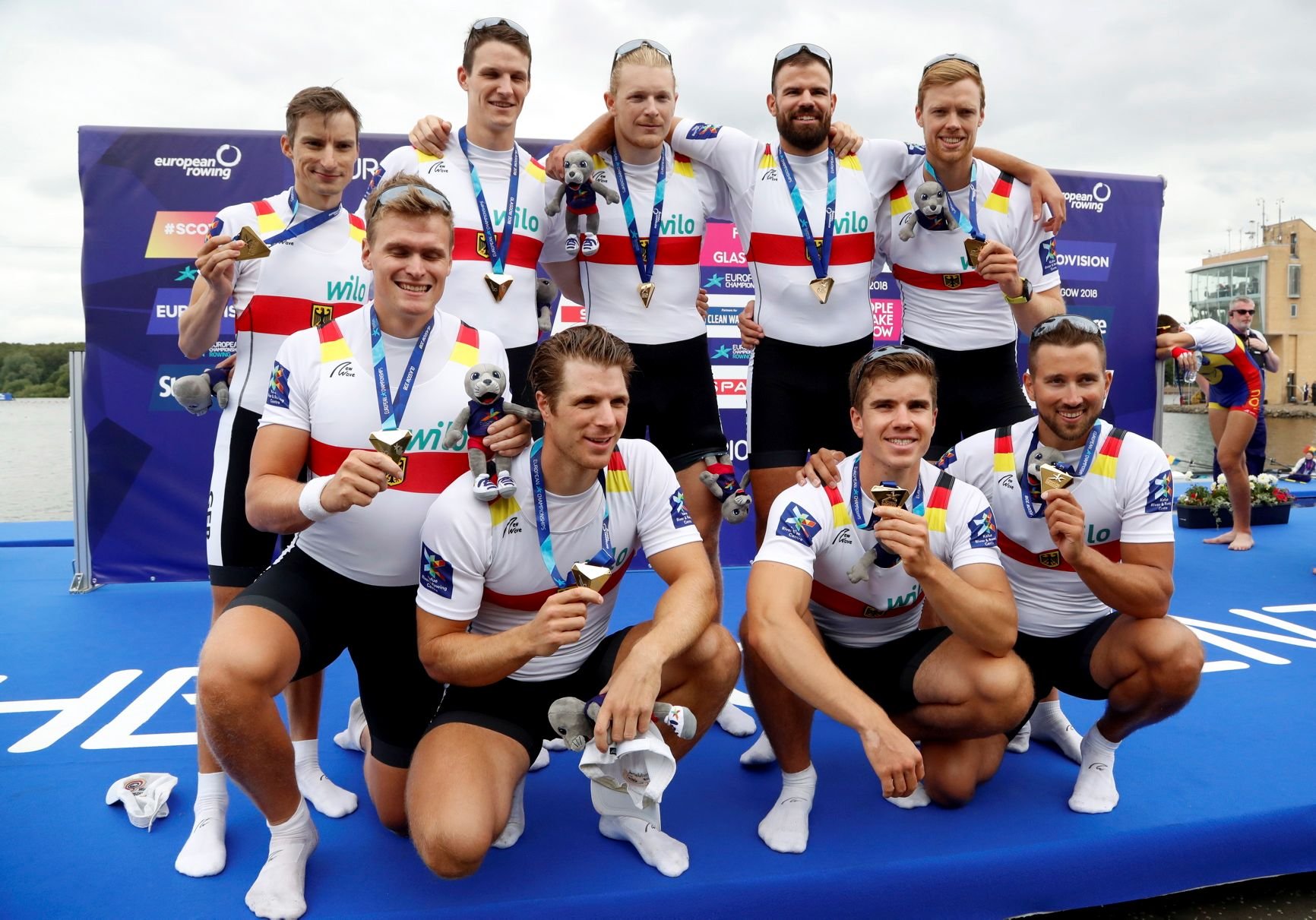 Maximilian Planer (2.v.r. hinten) und seine Kameraden im Deutschland-achter zeigen nach der Siegerehrung bei der Rudern-EM in Glasgow ihre Goldmedaillen.