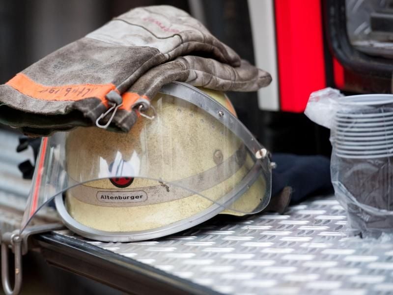 Ein Feuerwehrhelm liegt an einem Einsatzfahrzeug. Foto: picture alliance/dpa/Archivbild