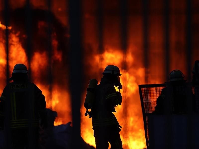Feuerwehrmänner löschen einen Großbrand. Foto: Hasan Bratic/dpa