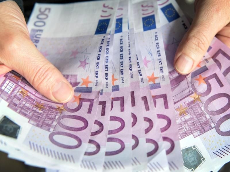 Eine Frau zählt 500-Euro-Geldscheine. Foto: Patrick Seeger/Archiv
