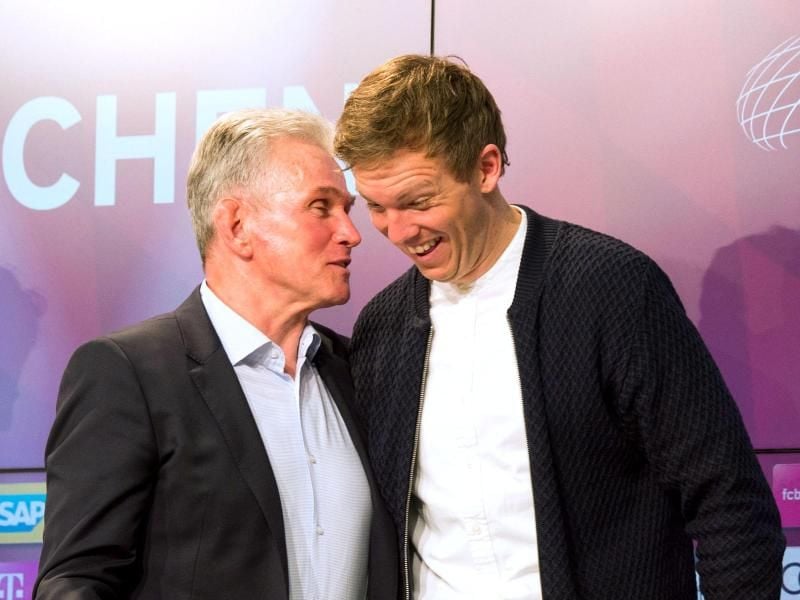 Bayern-Trainer Jupp Heynckes (l) und Hoffenheims Trainer Julian Nagelsmann plauschen bei einer Pressekonferenz. Foto: Lino Mirgeler