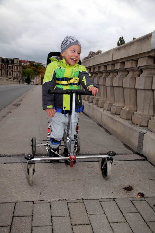 Große Schritte für Ben-Luca: Der an einer schweren Epilepsie-Form erkrankte Fünfjährige läuft mit dem Spezialwalker über die Auebrücke.