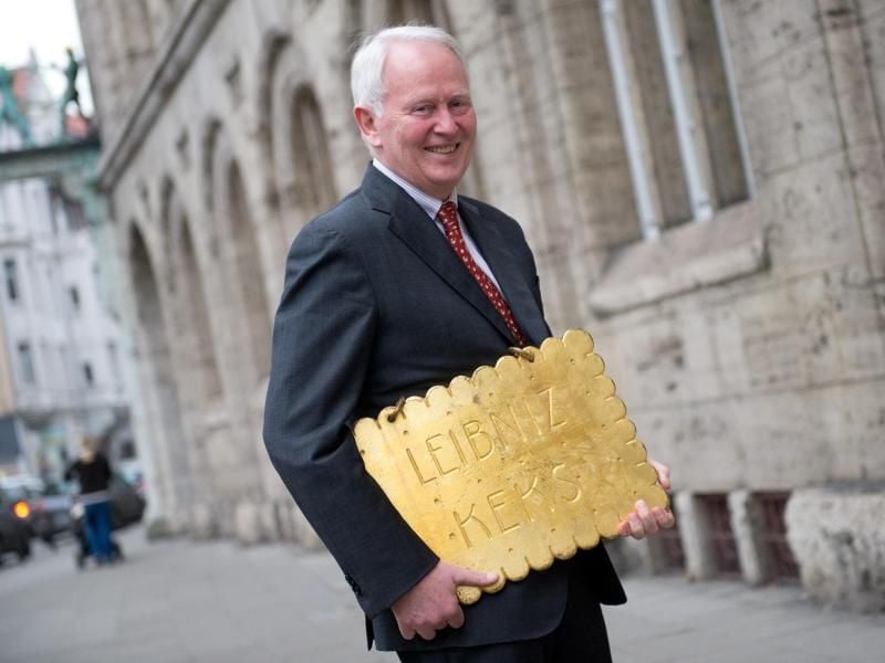 Firmenchef Werner M. Bahlsen steht mit dem Firmenwahrzeichen, dem zuvor gestohlenen goldenen Leibniz-Keks, vor dem Firmensitz. Foto: Julian Stratenschulte/Archiv