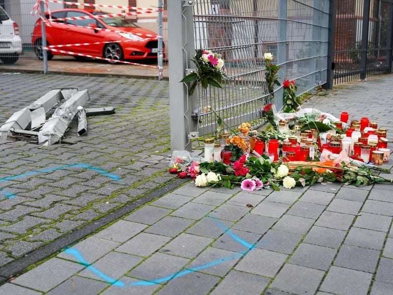 Blumen und Kerzen liegen an der Stelle, an der eine 31-jährige Frau in Limburg getötet wurde. Foto: Thorsten Wagner/dpa