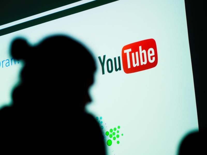 Ein Schatten vor einem Logo von YouTube. Foto: Nicolas Armer/Archiv