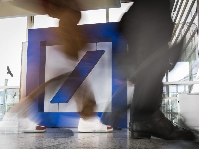 Menschen gehen an einem Logo der Deutschen Bank vorbei. Foto: Frank Rumpenhorst/Archiv