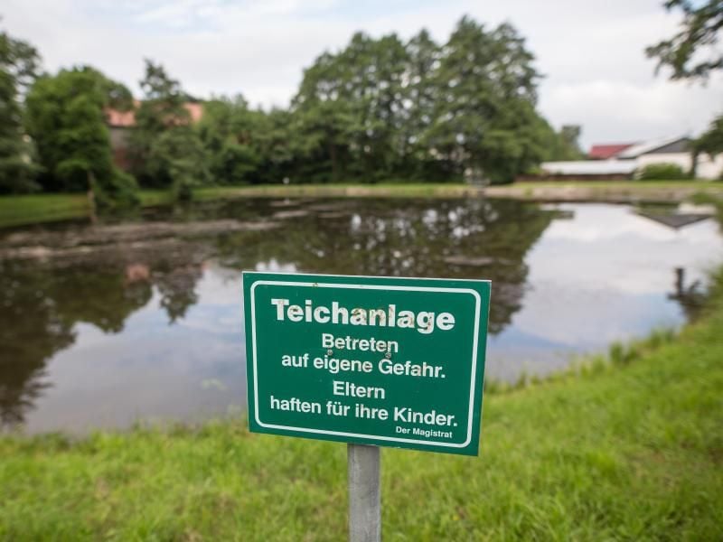 Ein Warnschild weist auf eine Teichanlage hin. Foto: Frank Rumpenhorst/dpa/Archivbild