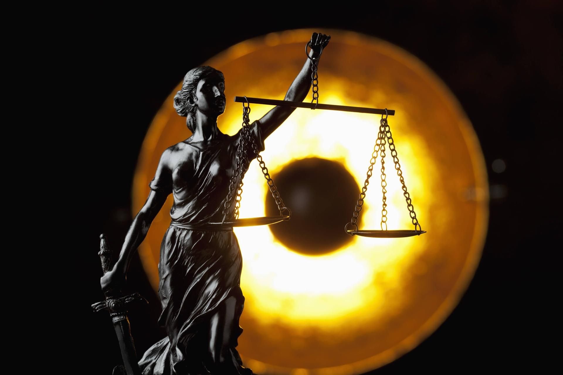 Justitia, die römische Göttin der Gerechtigkeit mit verbundenen Augen, Schwert und Waage.