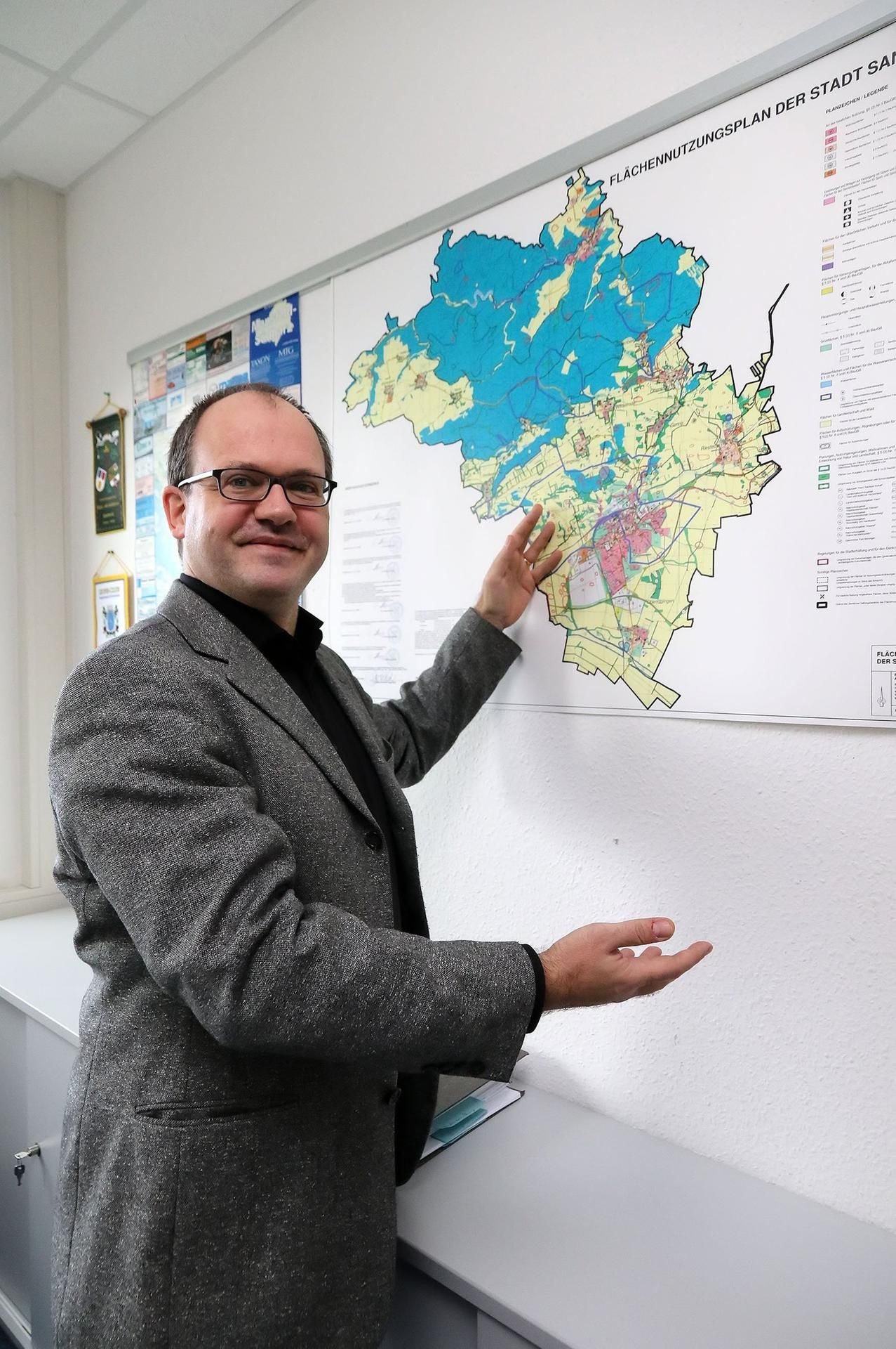 Matthias Knobloch vor dem Flächennutzungsplan der Stadt in seinem Büro.