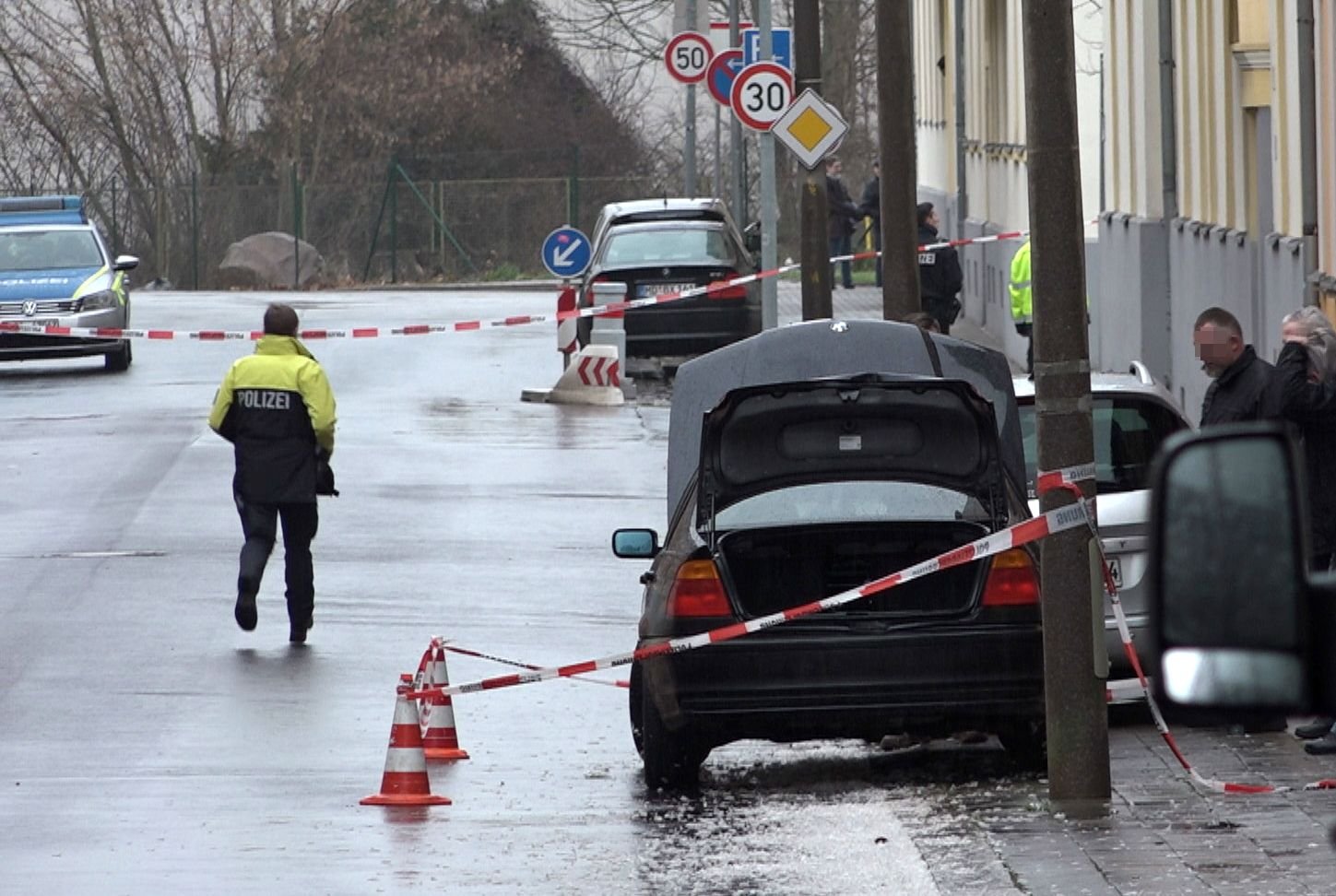 Polizisten stehen in Magdeburg neben einem Auto, das von Absperrband umringt ist. Das Fahrzeug war in der Nacht aufgefallen.