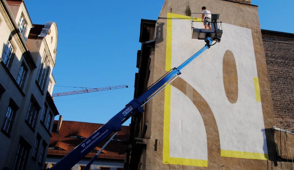 Mike Okay gestaltet die Fassade eines Gebäudes in der Kleinen Steinstraße mit einem stilisierten „R“.