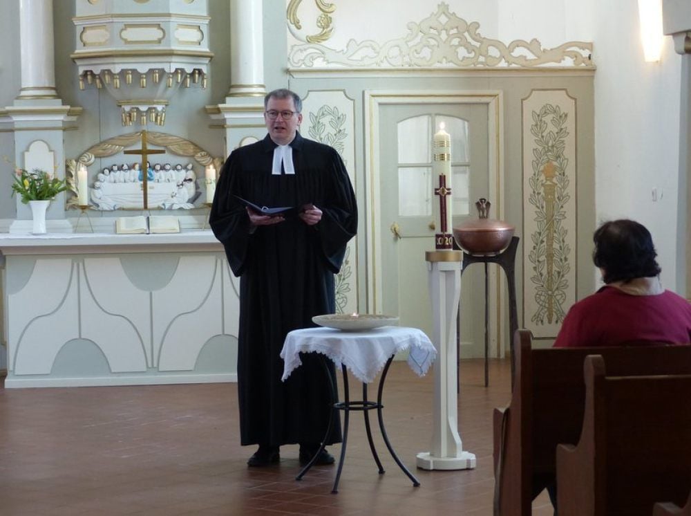 Pfarrer Albrecht Henning vor nahezu leeren Bänken in der Kirche in Krina.