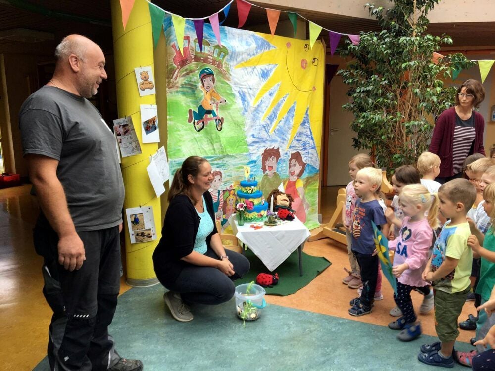 Steffen Bartnik (li.) und Johanna Richter (hockend) überreichen den Sonnenschein-Kindern die Spende.