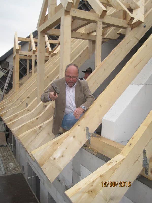 WG Einigkeit-Chef Peter Schröter schlägt beim Richtfest Über den Steinen 32/33 in Aschersleben einen Nagel in einen Dachbalken.