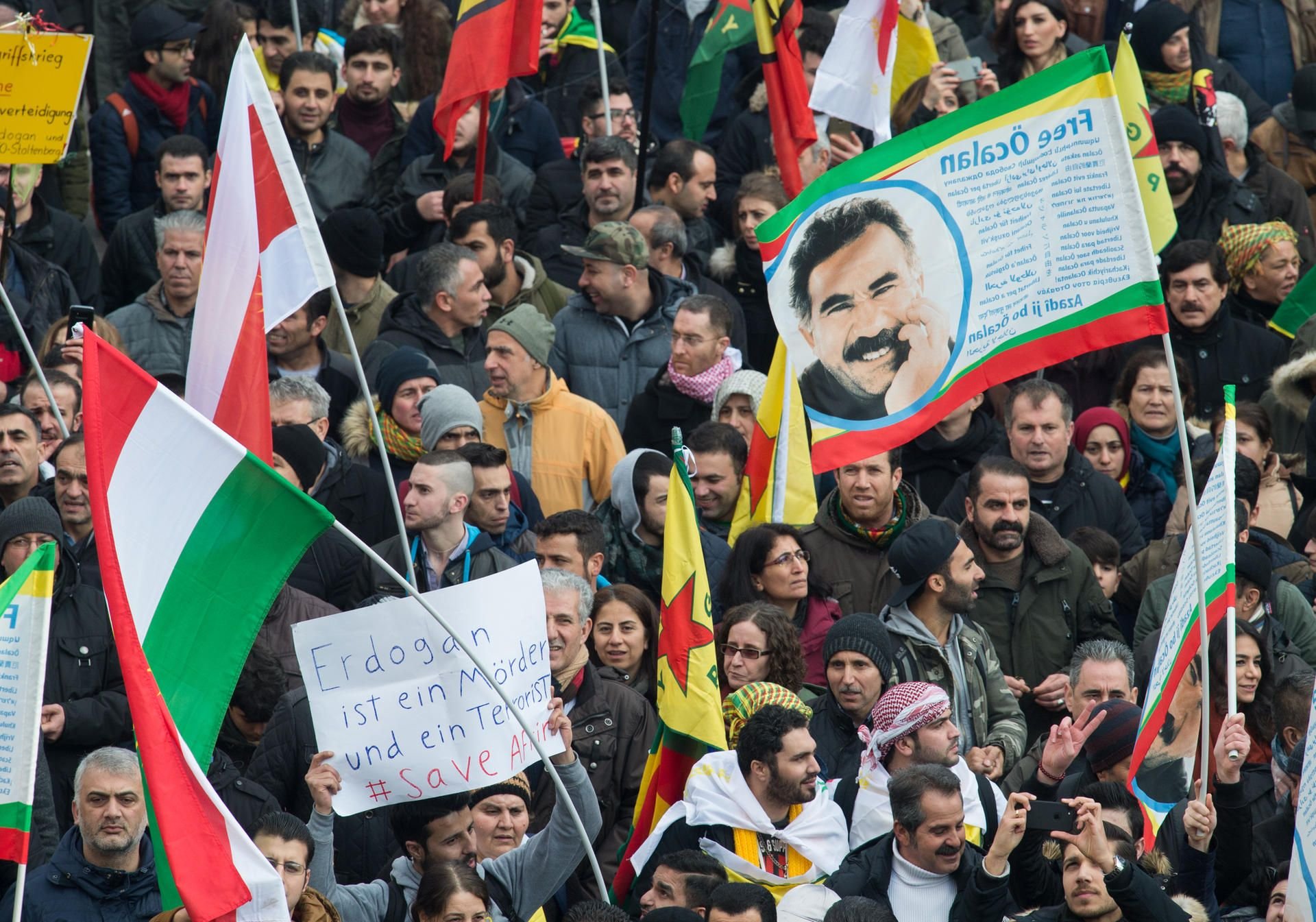 Teilnehmer einer Kurden-Demonstration protestieren am 27.01.2018 in Köln (Nordrhein-Westfalen) gegen die türkische Militäroffensive in Nordsyrien. Dabei wird auch eine Fahne mit dem Konterfei des inhaftierten PKK-Führers Öcalan mitgetragen.