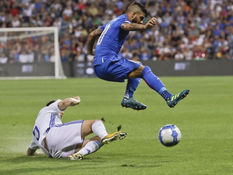 Der Italiener Lorenzo Insigne (r) weicht einer Grätsche von Israels Amor Melikson aus. Foto: Luca Bruno