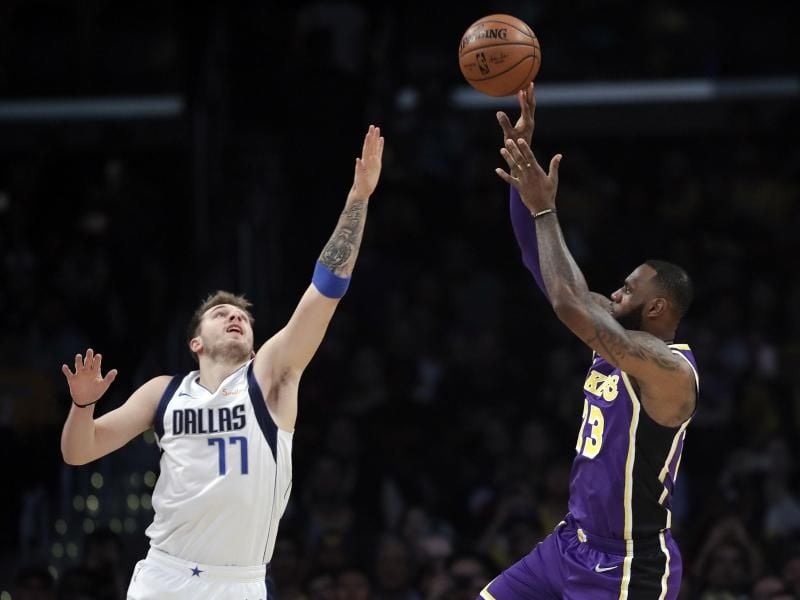 Mavericks-Neuzugang Luka Doncic (l) kommt gegen Lakers-Superstar LeBron James zu spät. Foto: Marcio Jose Sanchez/AP