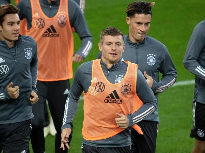 Toni Kroos (M.) wird sein 100. Länderspiel absolvieren. Foto: Federico Gambarini/dpa