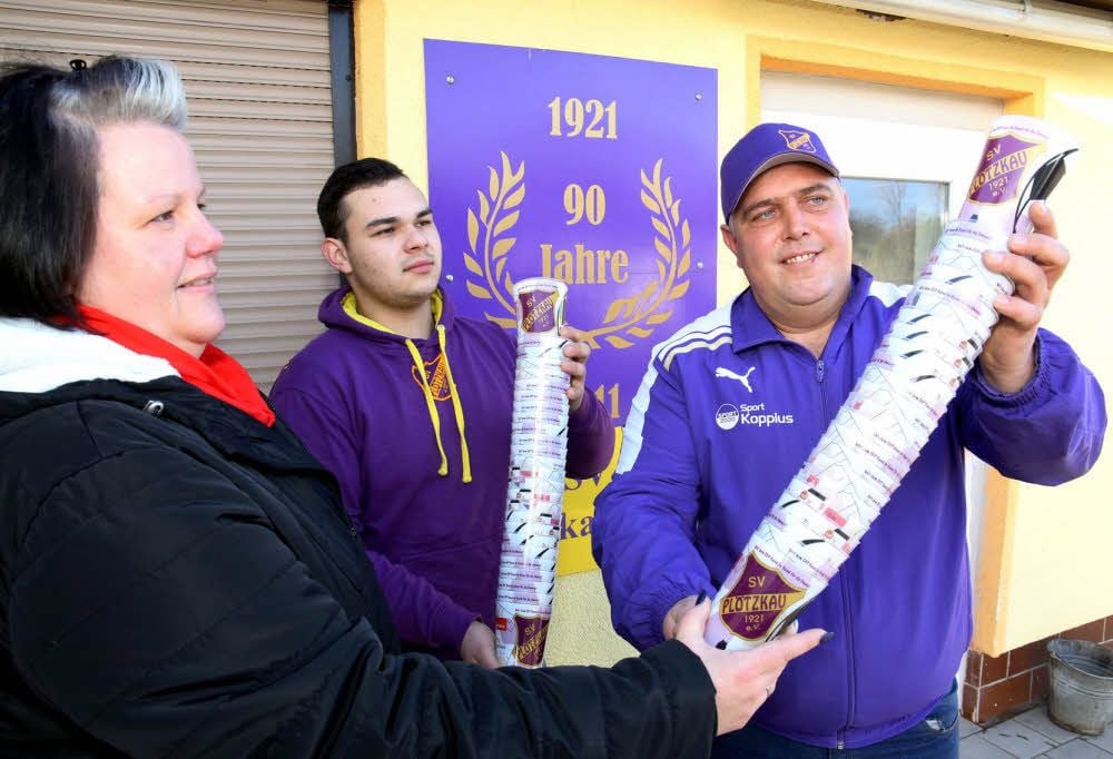 Wirtin Kathleen Seidel, Toni Beau von der Faninitiative Projekt 1921 und Fußball-Abteilungsleiter Denny Künstner-Lehmann präsentieren die neuen Mehrwegbecher aus Kunststoff.