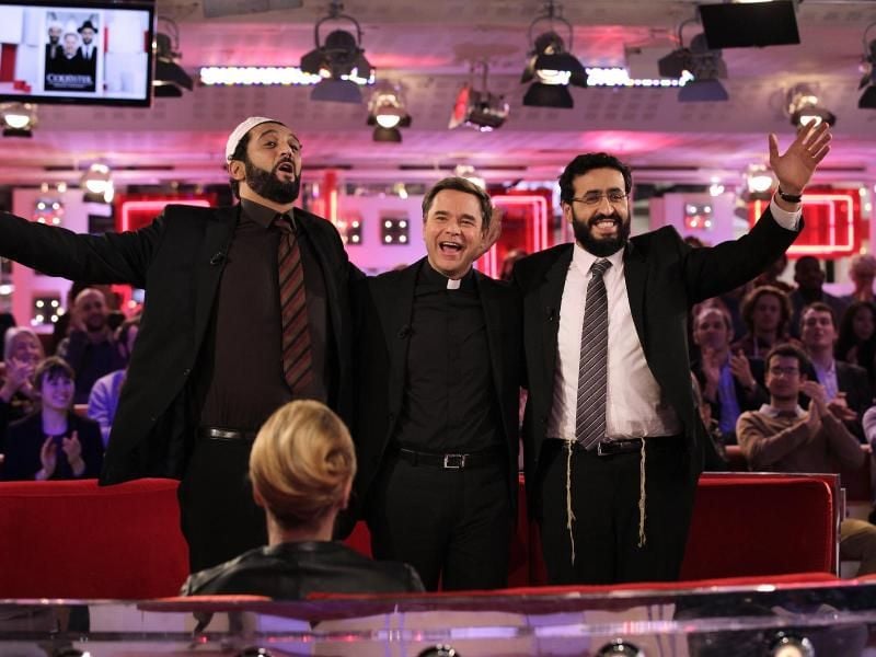 Der Imam Moncef (Ramzy Bedia, l), der Priester Benoit (Guillaume de Tonquedec, M) und der Rabbi Samuel (Jonathan Cohen, r) sollen in einer Band zueinanderfinden. Foto: Neue Visionen