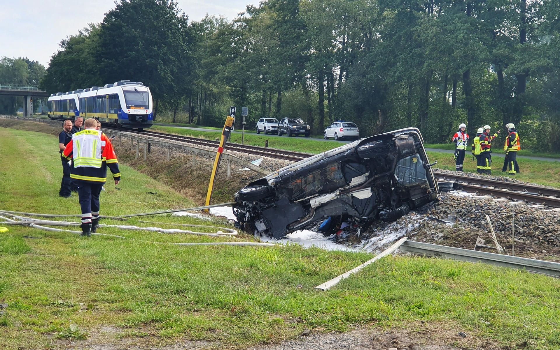 Rettungskräfte stehen an einer Unfallstelle nahe einem unbeschranktem Bahnübergang bei Vechta: Der Fahrer des Autos kam ums Leben.