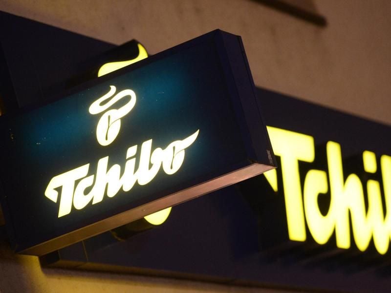 Die Leuchtreklame von "Tchibo" vor einem ihrer Geschäfte. Foto: picture alliance / Patrick Seeger/dpa/Archiv