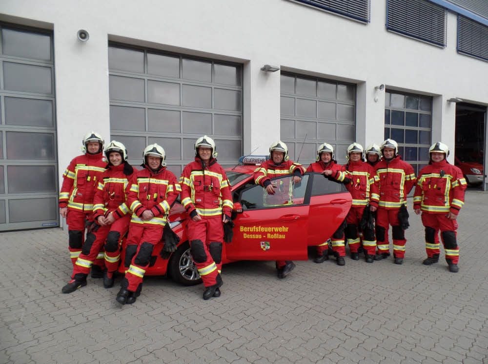 Eine Wachabteilung der Berufsfeuerwehr zeigt sich stolz mit der neuen schicken Einsatzkleidung.