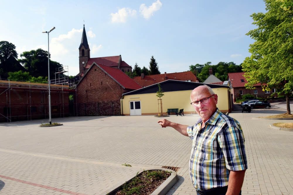Ortsbürgermeister Siegfried Haaßengier zeigt auf den Dorfplatz.