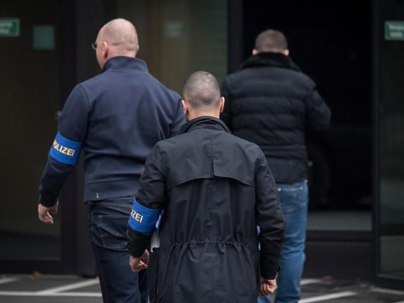Zivilfahnder der Polizei betreten die Zentrale der Deutschen Bank in Frankfurt. Foto: Boris Roessler
